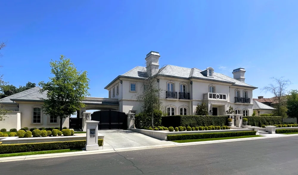 Angled side view of Campos Estate, its driveway, and landscaped grounds.