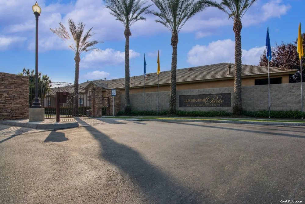 Jasmine Parke apartment-community entrance with palm trees and a gated drive.